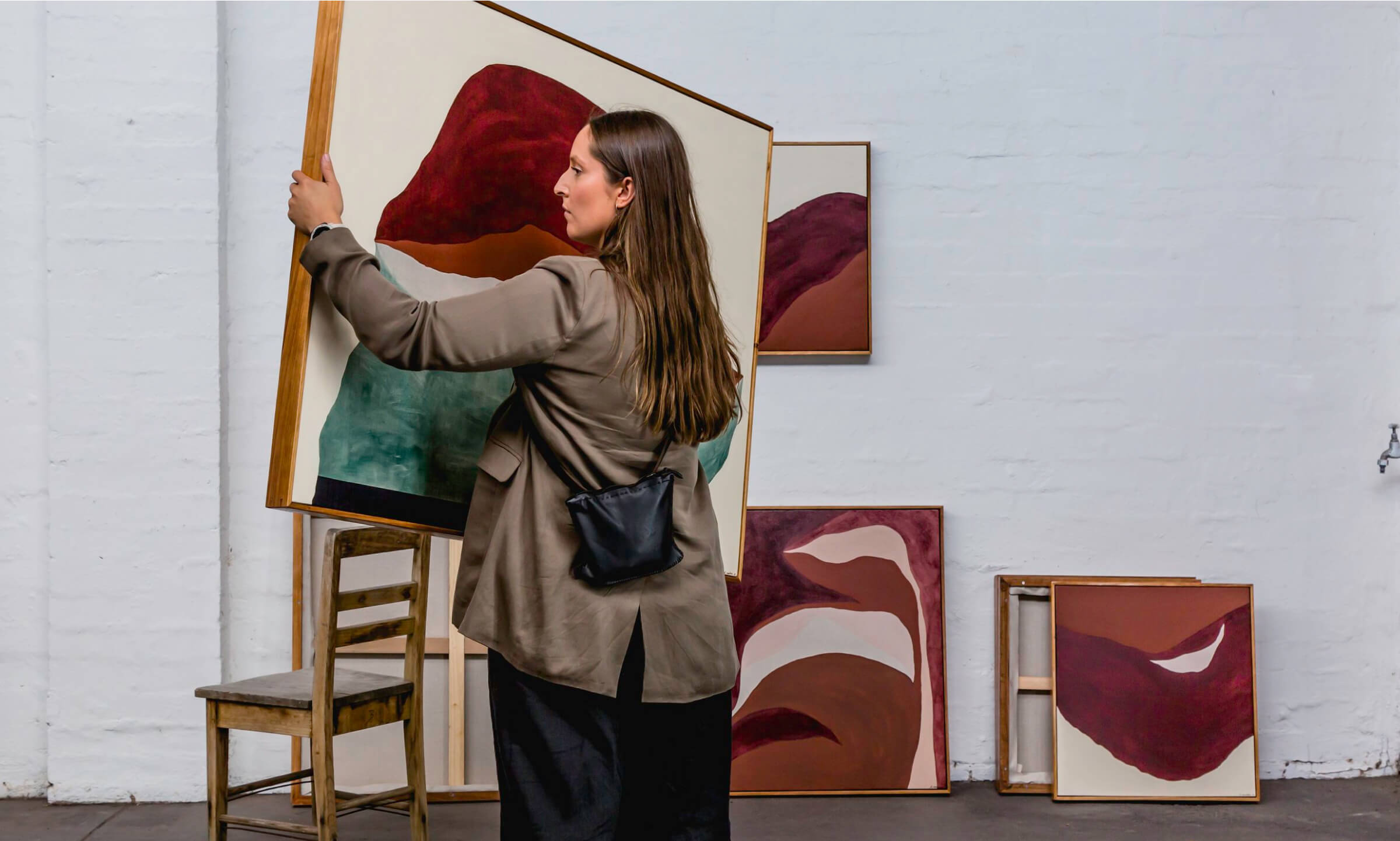 photo of a lady hanging an original artwork