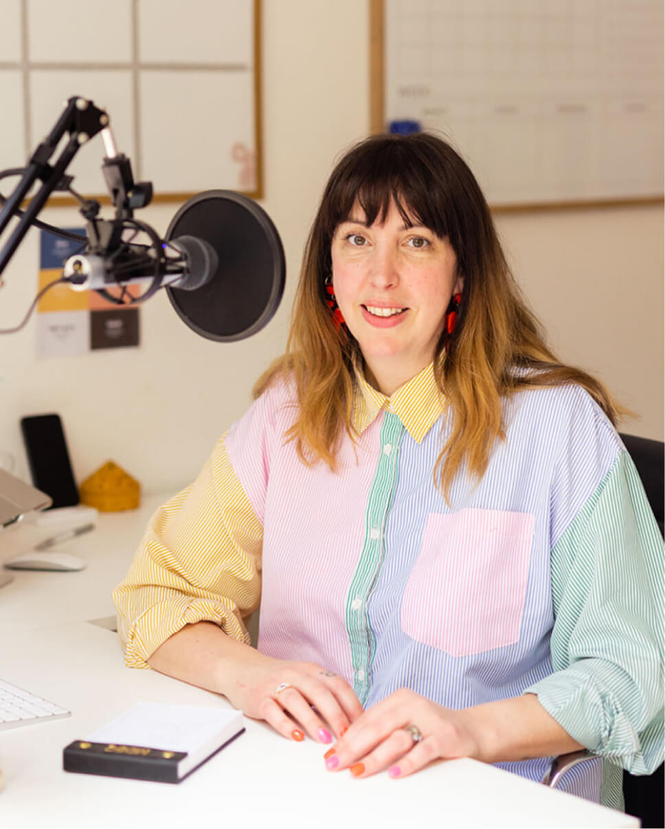 portrait of a lady in front of a podcast microphone
